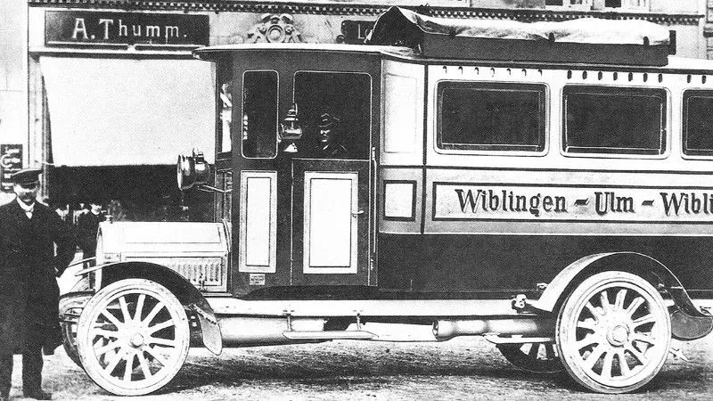 Karl Heinrich Kässbohrer steht stolz neben dem ersten Omnibus, der Wiblingen und Ulm verbindet