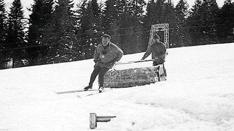 Un homme roule manuellement sur la piste de ski avec un rouleau à main