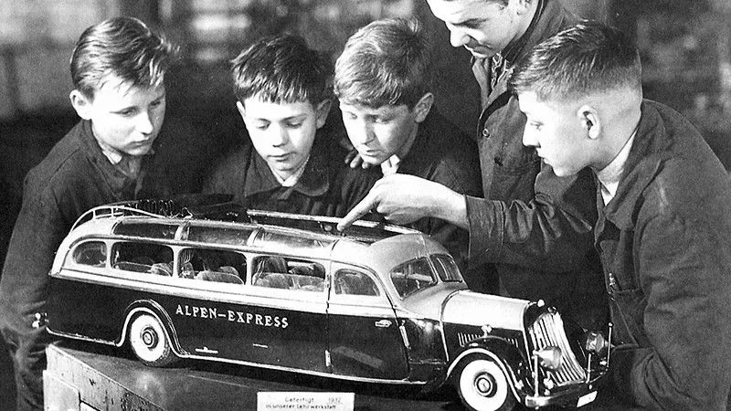 Vier Jungen lassen sich interessiert ein Modell des Alpen-Express erklären