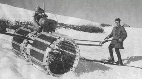 Zwei Männer walzen von Hand die Piste